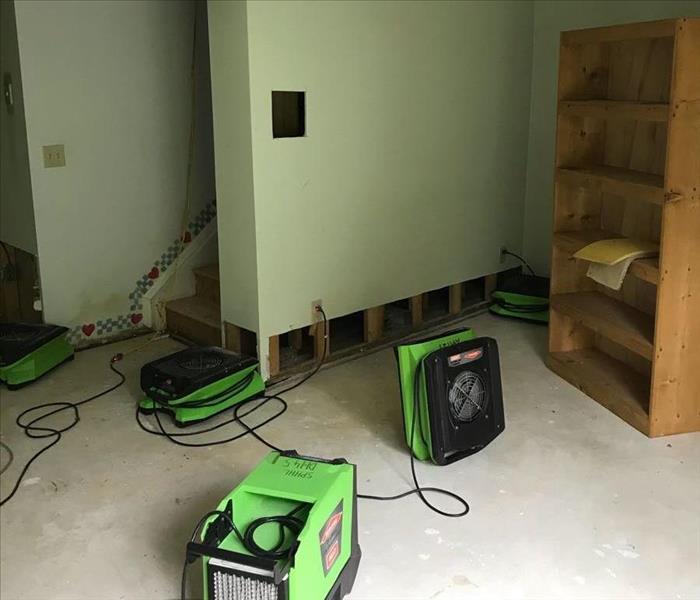Carpet and parts of drywall removed with air movers drying out the basement