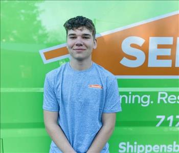 Technician standing smiling in front of green van