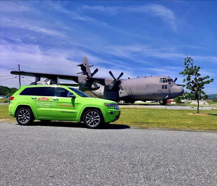 SERVPRO vehicle parked in front of a military plane