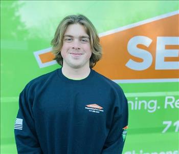 Servpro employee standing in front of a company van